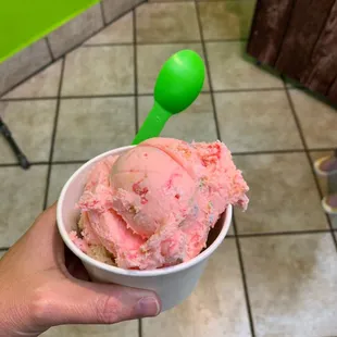 a hand holding a cup of ice cream