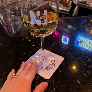 a hand holding a glass of wine