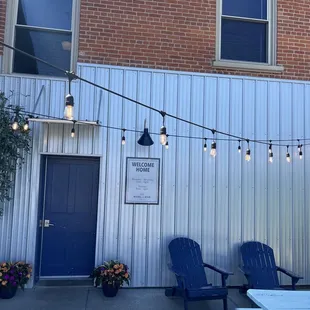 a patio area with blue chairs and lights