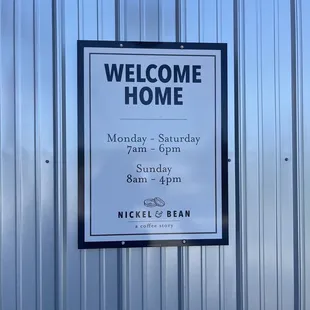 a welcome sign in front of a metal building
