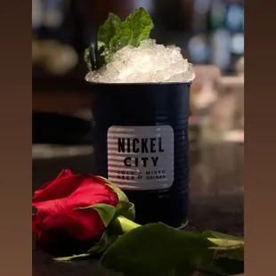 a rose and ice in a cup