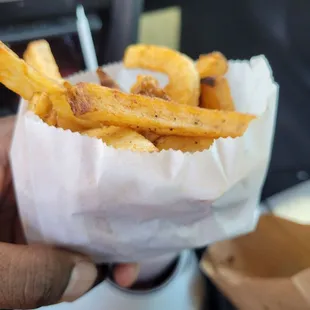 a person holding a basket of french fries