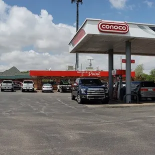 a gas station with cars parked in the lot