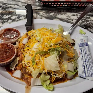 a plate of taco salad and condiments