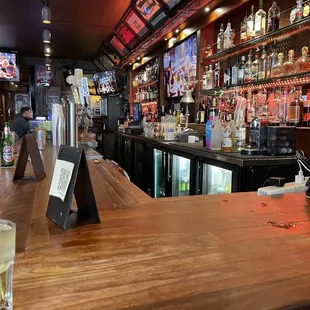 a view of a bar with a wooden bar top
