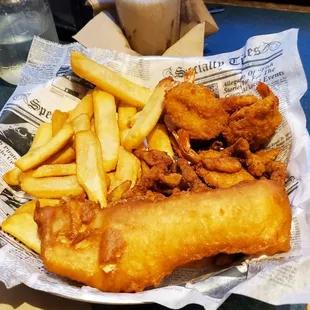 Half of a two piece fish with clam strips and shrimp.