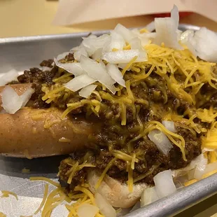 a chili dog with onions and cheese