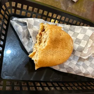 a half eaten sandwich in a basket