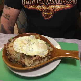 The hungry man skillet with potatoes, corn beef hash, onions, peppers, cheese, under two over easy eggs! Yum