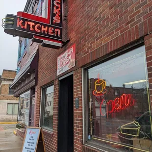 a brick building with a neon sign