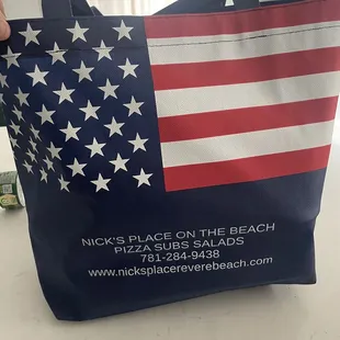 a person holding a bag with a flag on it