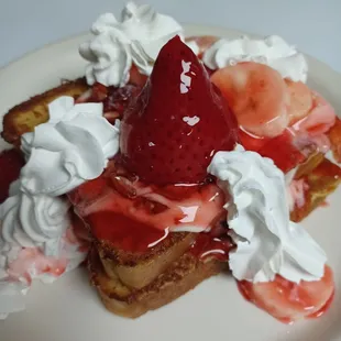 Stuffed French toast; stuffed with cream cheese filling, topped with delicious strawberries, bananas, whip cream, and pecans