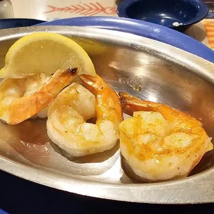 shrimp in a bowl with lemon wedges
