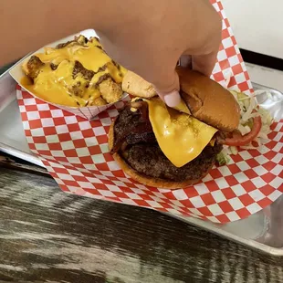 a hand holding a cheeseburger