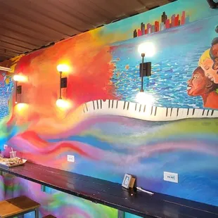 a colorful mural of a couple eating pizza