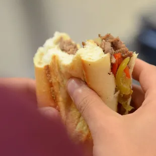 a hand holding a sandwich