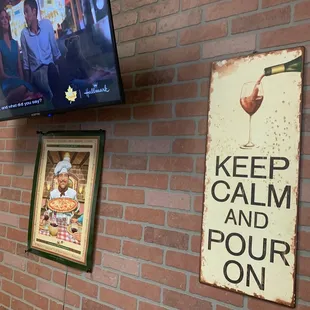 a brick wall with a sign that says keep calm and pour on