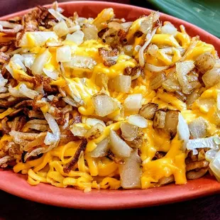 a plate of hash browns with onions and cheese