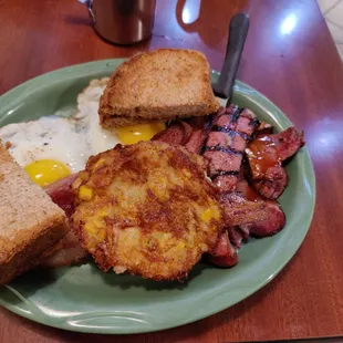 Smokehouse breakfast platter 2 eggs  2 cheesy potato pancakes Smoked brisket with BBQ sauce  Smoked sausage And bacon.
