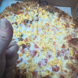 Breakfast pizza  with homemade crust perfect cornmeal dusting. We got half bacon &amp; sausage and tomato. Personal is 12 in. Awesome.