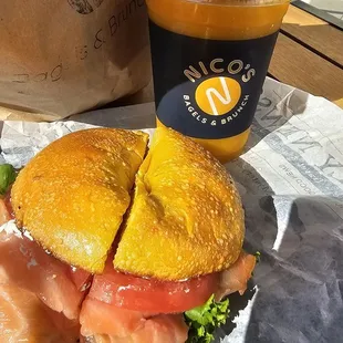 Salmon bagel sandwich on egg bagel with mango smoothie.