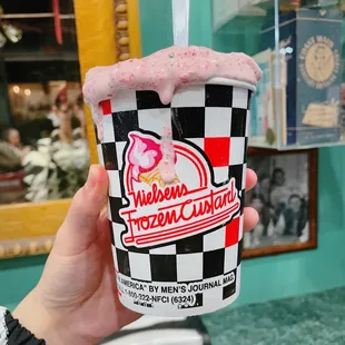 a person holding a cup of ice cream