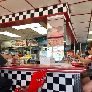 a man and a woman sitting at a diner counter