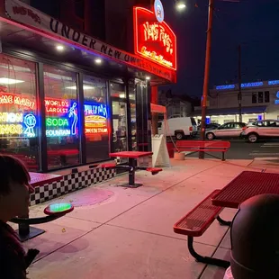 a young boy standing in front of a diner