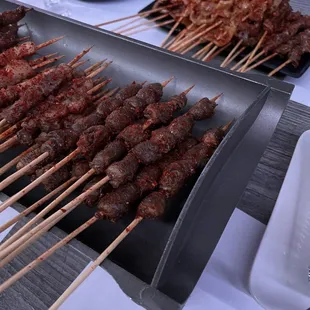 skewers of meat on a grill