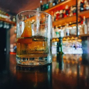 a glass of whiskey on a bar counter