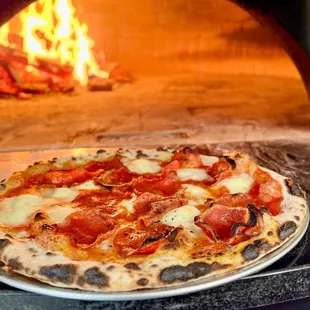 a pizza in front of an oven