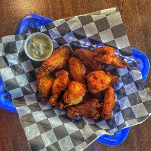 a basket of fried chicken with a side of ranch dip