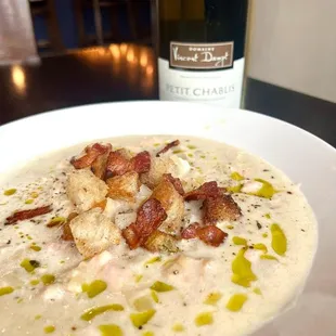 a bowl of soup and a bottle of wine