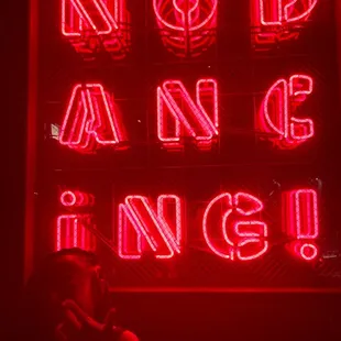 a woman in front of a neon sign