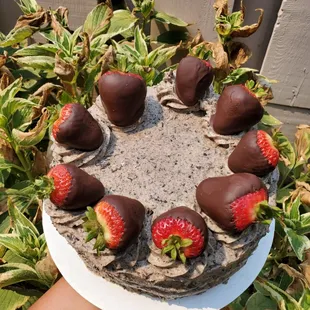 a cake with chocolate covered strawberries