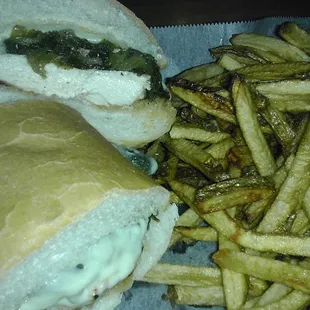 Chicken &amp; greens sandwich (grilled chicken breast, Italian fried greens, provolone), with a side of fries.