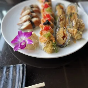 a plate of sushi and chopsticks