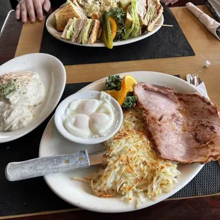 Dinner style ham &amp; eggs with poached eggs, biscuits and side of gravy.