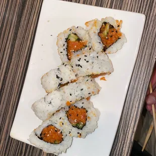 a plate of sushi with chopsticks