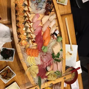 a wooden boat filled with sushi
