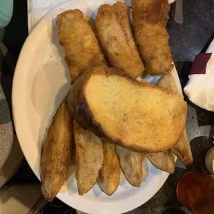 Cod dinner with potato wedges and garlic bread
