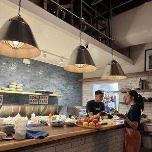 a man and a woman preparing food in a restaurant