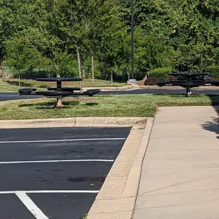 a parking lot with picnic tables and benches