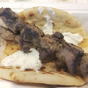 skewered meat on a pita