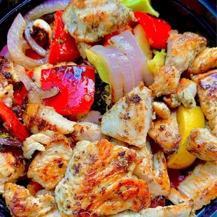 chicken, peppers, and onions in a black bowl