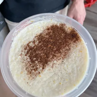 a person holding a bowl of rice pudding