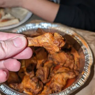 a hand holding a piece of chicken