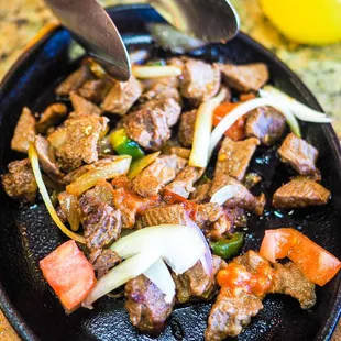 a skillet of beef and vegetables