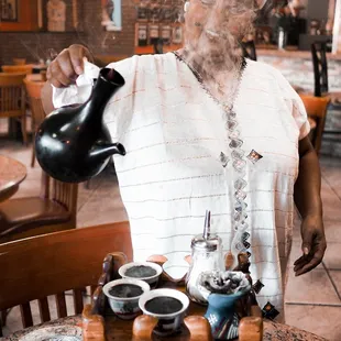 a woman pouring tea from a teapot