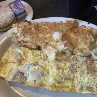 Ham and cheese omelette with hash browns and English muffin.